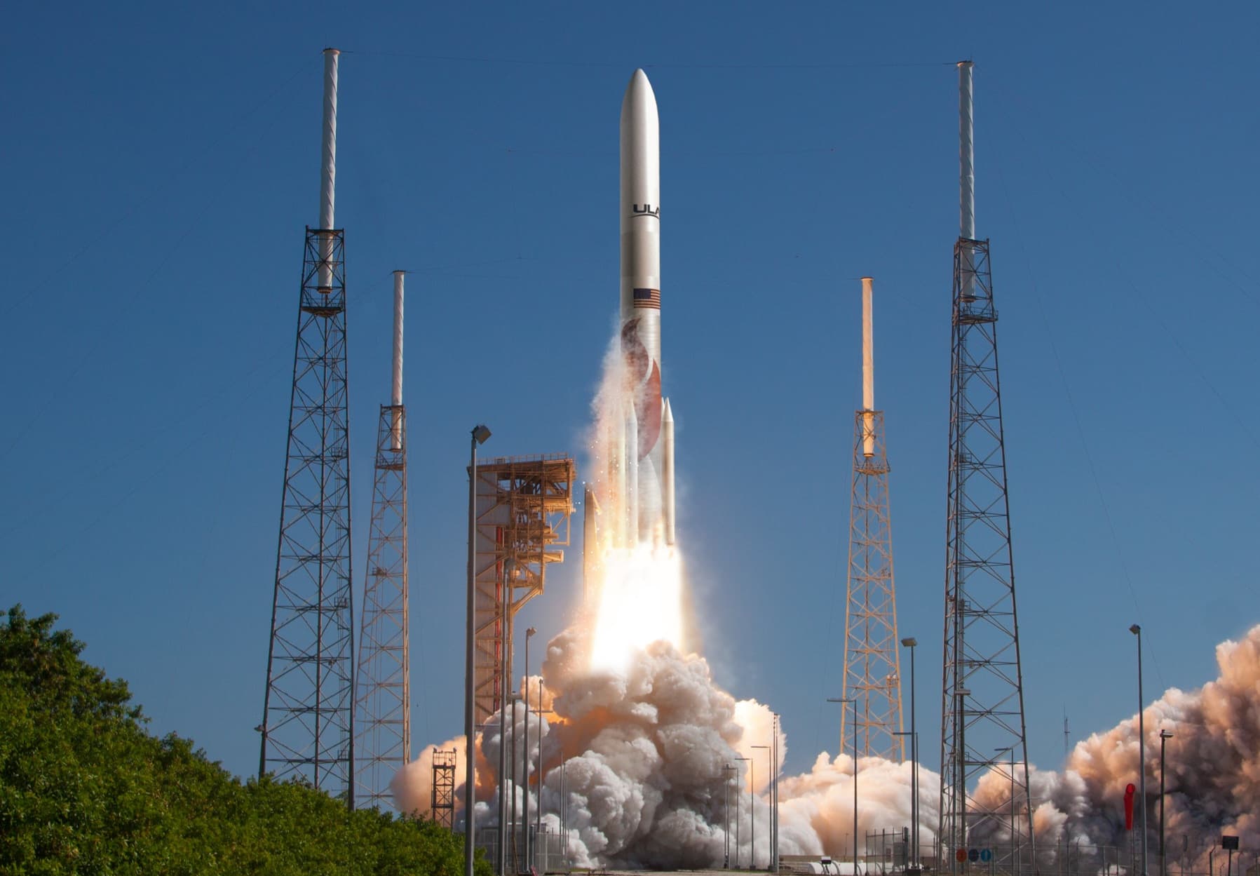 Artist's render of a Vulcan rocket with six solid boosters lifting off between the lightning towers at Space Launch Complex 41